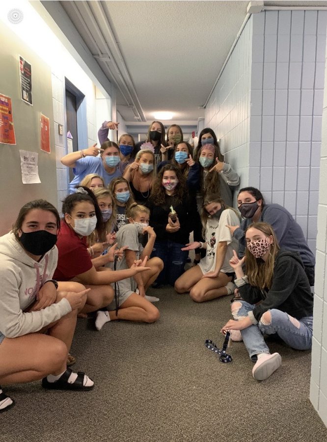 Morgan Festa (middle) and Carley Hall (right), along with their floor, celebrate Festa’s 18th birthday with a chocolate cupcake while wearing the required masks.