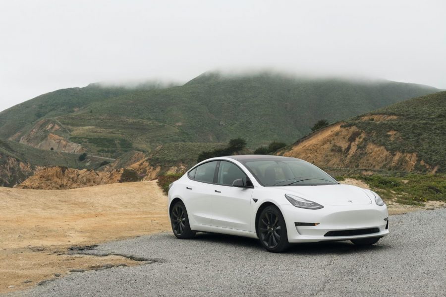 A white Tesla sedan parked on the road.