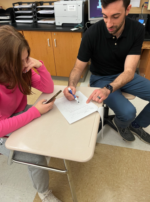 Freshman Paige Drazenovic ignores Teacher Nicholas 
Gebhardt while on her phone as he takes her through work.
