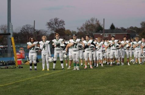 The Kinnelon High School football team salutes the flag during the national anthem, as they play in the Semifinal round of the Group 1 North NJSIAA tournament.