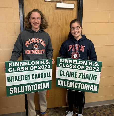 Valedictorian Claire Zhang and Salutatorian Braeden Carroll pose with their signs of academic achievement.