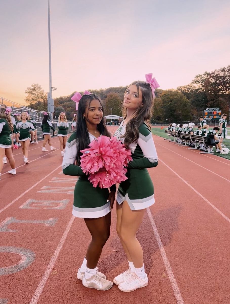 Junior Cheerleaders Sofia Solensky and Natalia Carvajal with their pink bows and pink pom poms