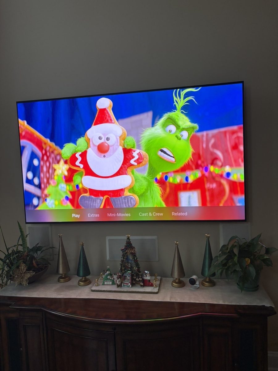 Cozy holiday living room scene with festive decor, with an animated Christmas movie playing.
